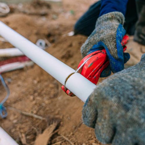 Plumber Hillcrest 5 Irrigation Construction Woker using a PVC pipe cutter to cut a polypropylene sprinkler line in new construction outdoors